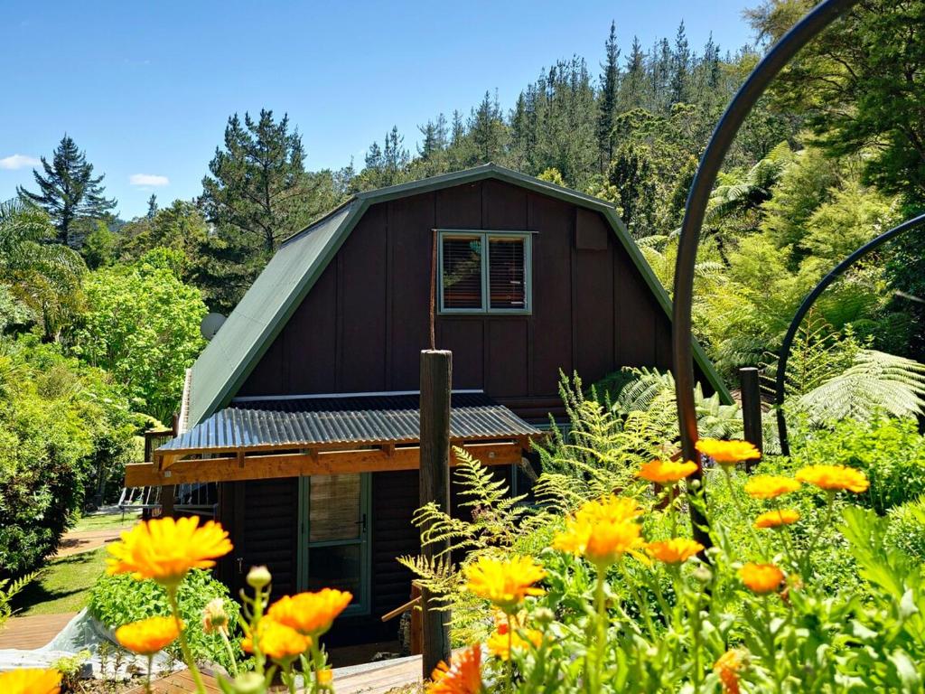 a small house with a garden in front of it at Fernside Tranquil Retreat in Pauanui