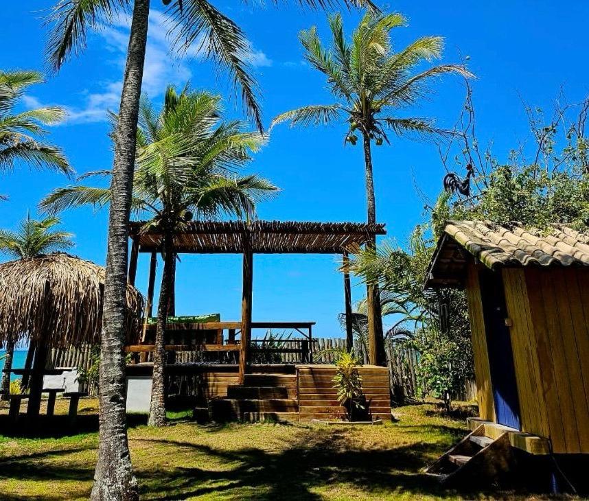 a resort with palm trees and a gazebo at Varanda do Mar Caraíva Oceanfront in Porto Seguro