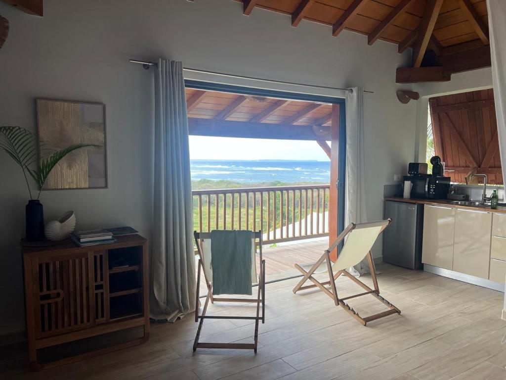 a kitchen with two chairs and a sliding glass door at Sukha Lodge in Le Moule