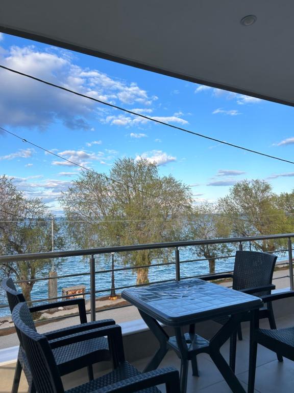 a balcony with a table and chairs and a view of the water at Serene beach house in Diakopto