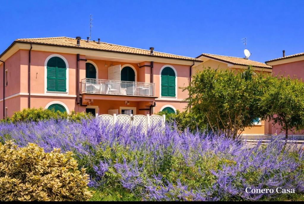 a house with a field of purple flowers in front of it at Conero Casa - Marcelli di Numana in Piazzale Tremiti 7 con Parcheggio Esclusivo in Marcelli