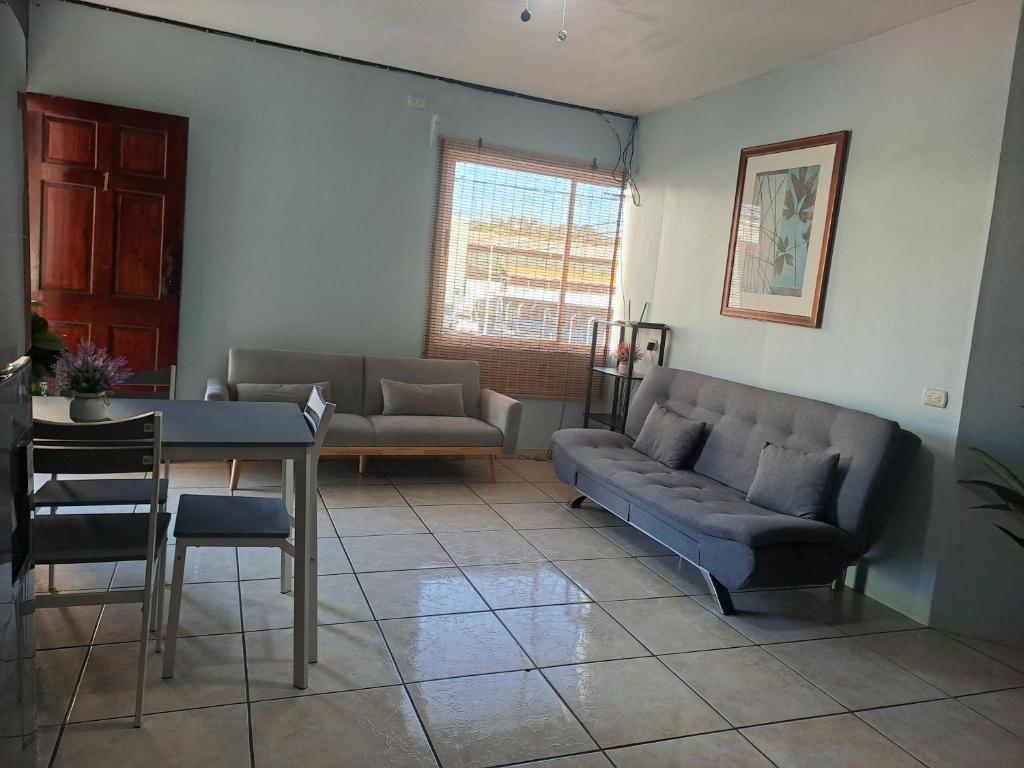 a living room with a couch and a table at Quepos Explorers Hub Spacious Apartment in Quepos