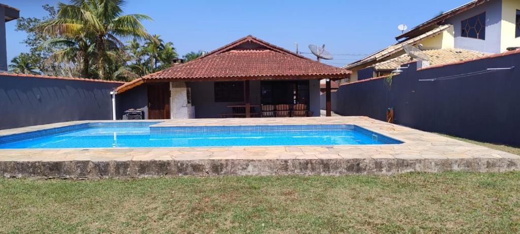 a swimming pool in front of a house at Condominio Morada da Praia in Bertioga