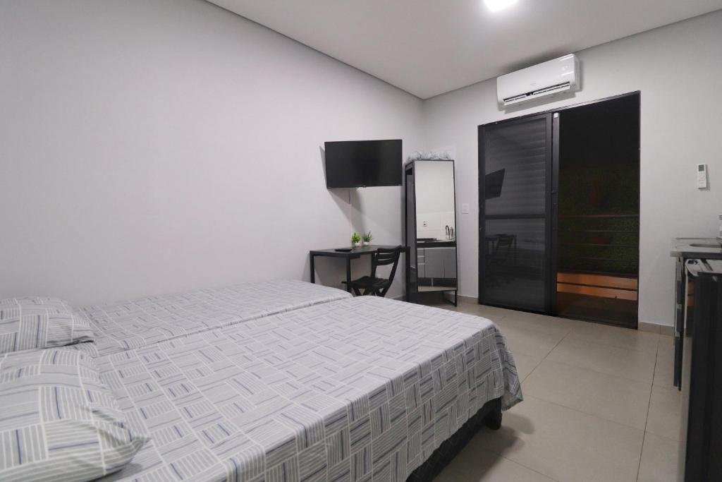 a bedroom with a bed and a flat screen tv at Studio III - Centro Jundiaí - Ar Condicionado in Jundiaí