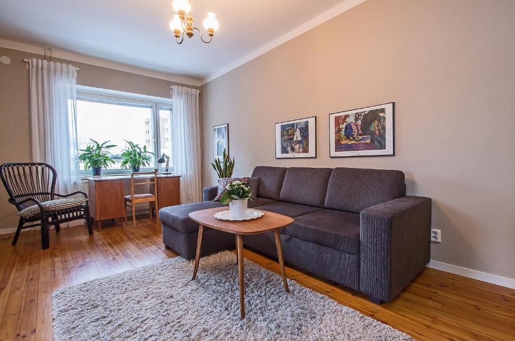 een woonkamer met een bank en een tafel bij Apartment Savonkatu 25 in Kuopio