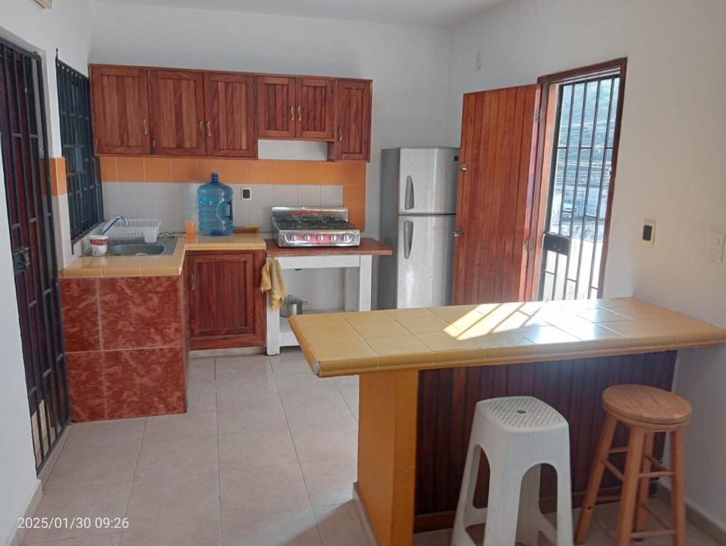 a kitchen with wooden cabinets and a counter top at Comfortable, bright and compact in Tembladera