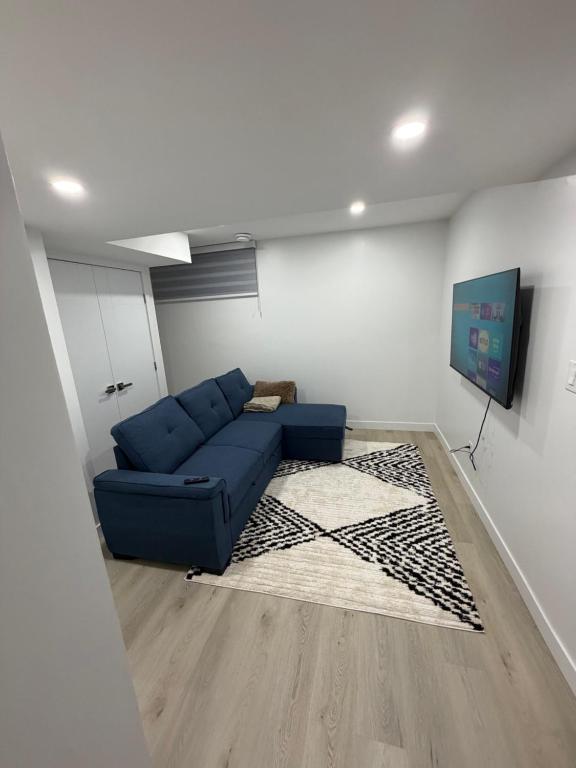 a living room with a blue couch and a rug at Granite Grove Suite in Winnipeg