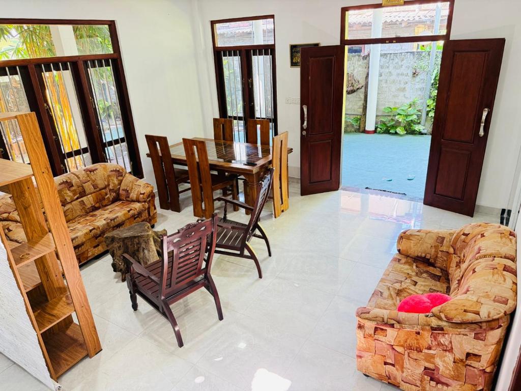 a living room with a couch and a table and chairs at Arumathi Villa in Bentota