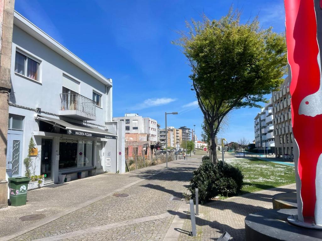 a street in a city with a tree and buildings at Casa Magenta - Alojamento Local in Trofa