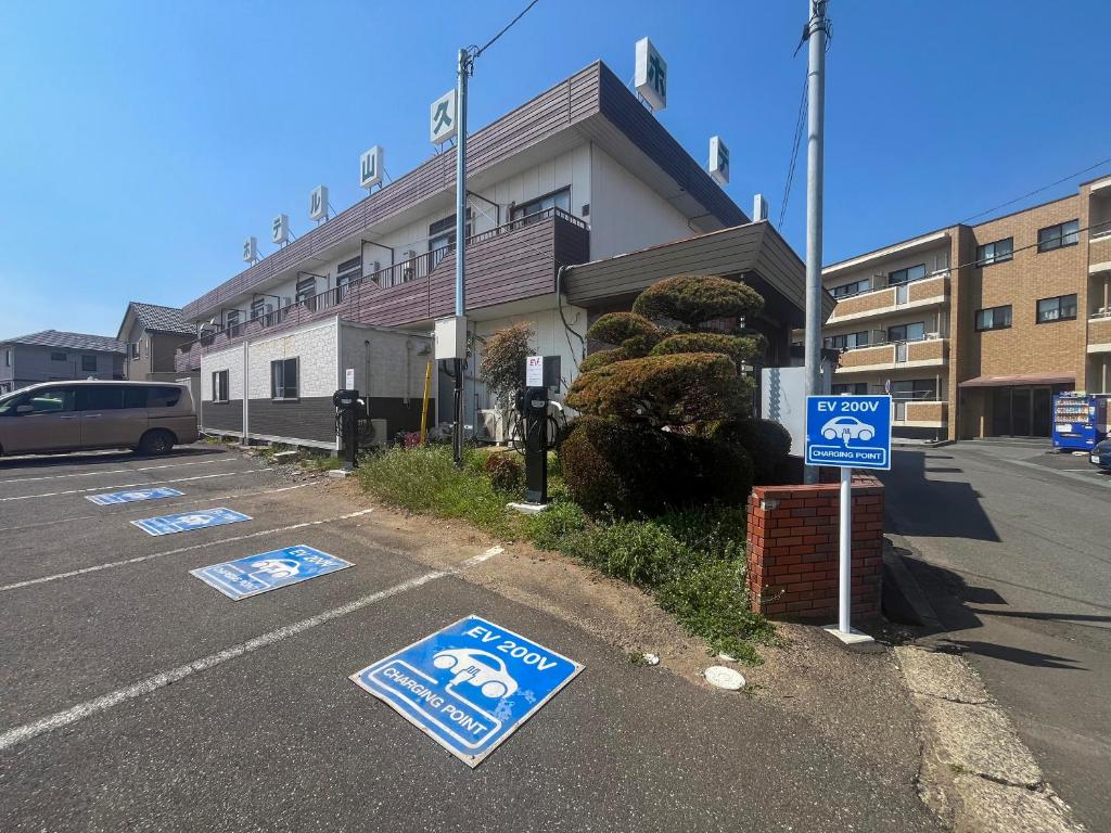 a parking lot with parking signs in front of a building at Hotel Sankyu in Tsukuba