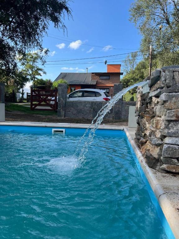 a water fountain in a swimming pool at Cabaña Tres linas in Villa General Belgrano