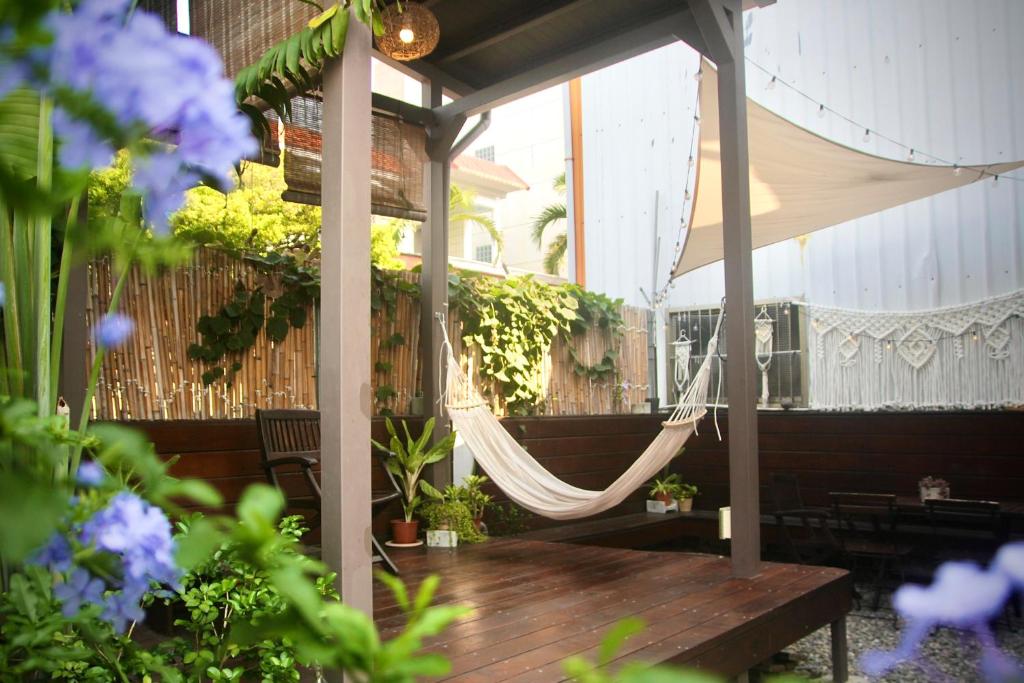 a porch with a hammock and a wooden table at 都蘭朋友家 Dulan Friends Hostel in Donghe