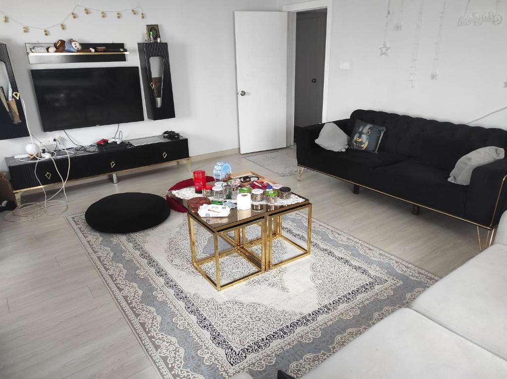 a living room with a black couch and a coffee table at Hostel in Yakuplu