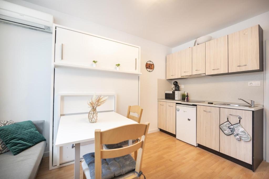 a small kitchen with a white table and a white counter at Boho Spa Apartments with Sauna in Sofia