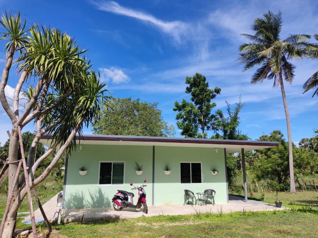 a house with a motorcycle parked in front of it at Kiang Khao Bungalow in Sam Roi Yot