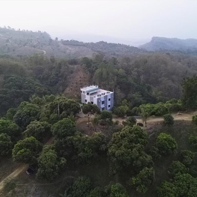 an aerial view of a white building in the middle of a forest at Sky n Valley in Bāndarban