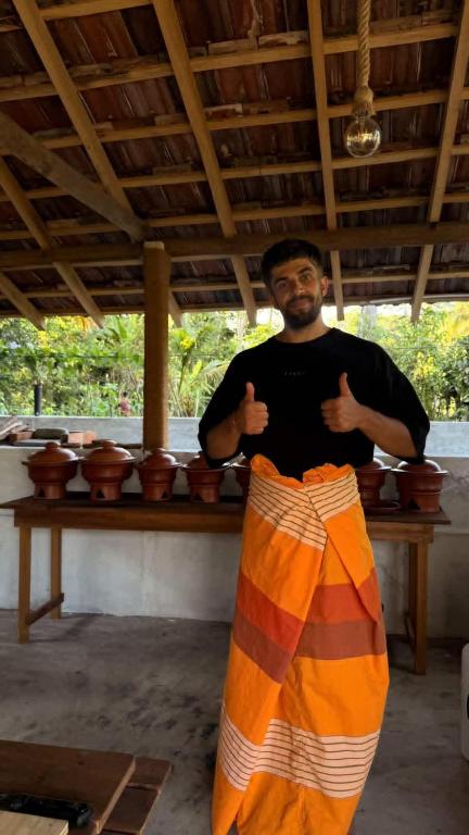 a man standing in front of a table with his hands up at Ovis kitchen in Matara