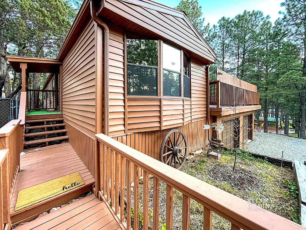 a cabin with a wooden deck with a porch at Ruidoso Mountain Getaway Centrally Located in Ruidoso