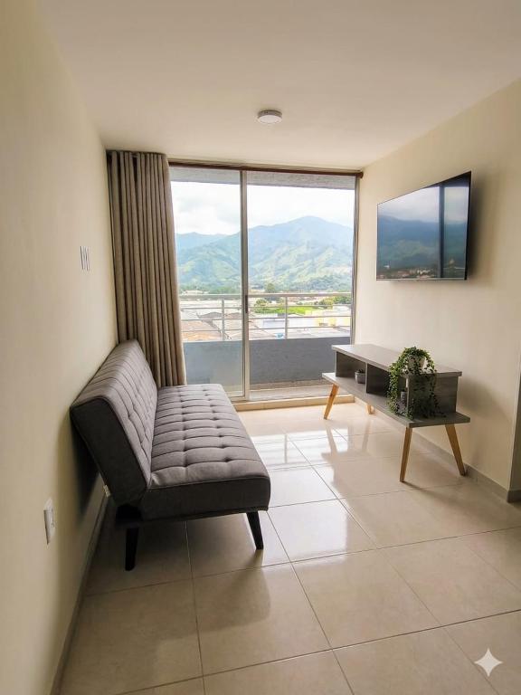a living room with a couch and a large window at Apartamento de 3 habitaciones al Norte de Armenia - excelente ubicación - parqueadero privado in Armenia