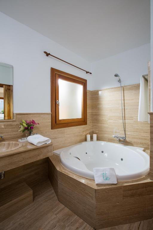 a large bathroom with a tub and a mirror at Boutique Hotel El Tio Kiko in Agua Amarga