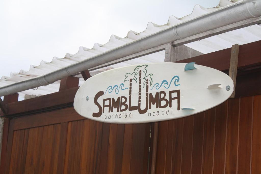 a sign on a building with a surfboard on it at Samblumba Hostel Trindade in Trindade