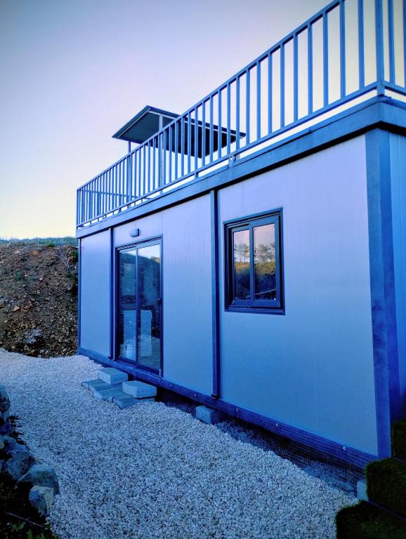 a blue and white house with a staircase on it at Anastasi Tiny Homes- Mountain Views, Garden & Terrace, Pet Friendly in Kakopetria