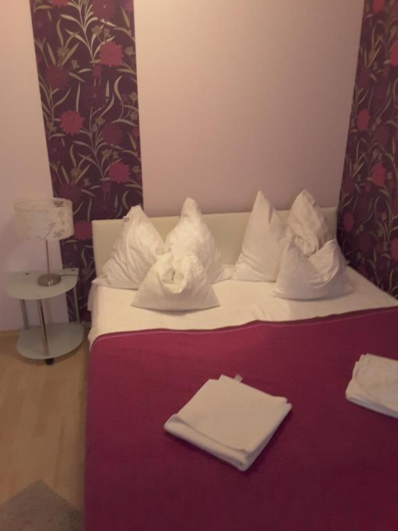 - un lit avec des draps blancs et des serviettes blanches dans l'établissement Isabell Apartments Győr, à Győr