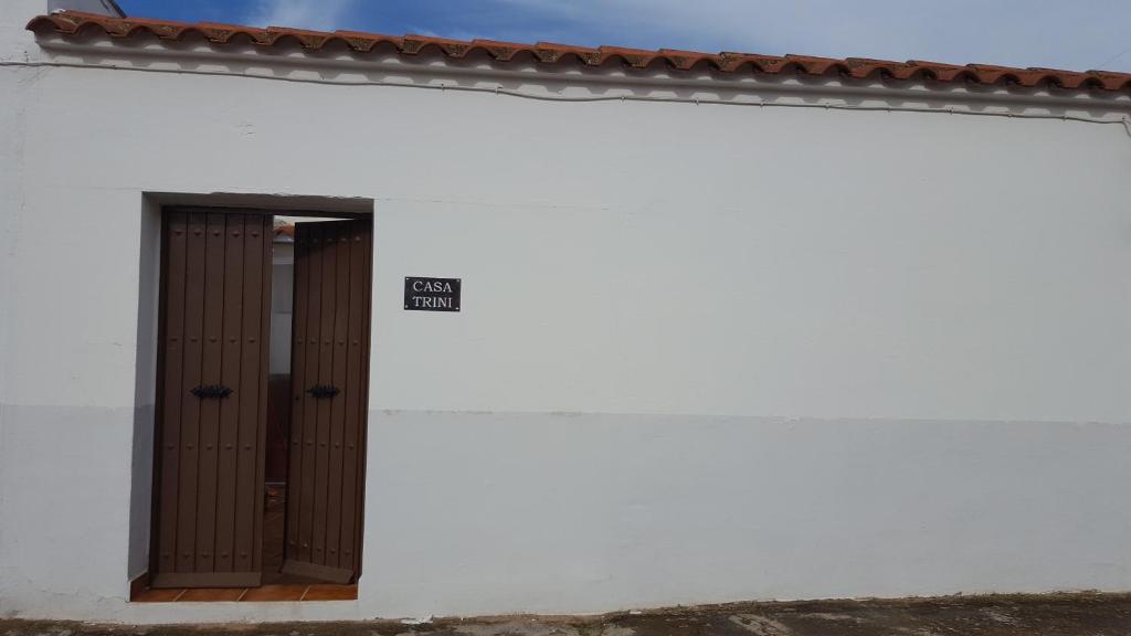 un edificio blanco con una puerta y una señal en él en Casa Trini, en Torremegía