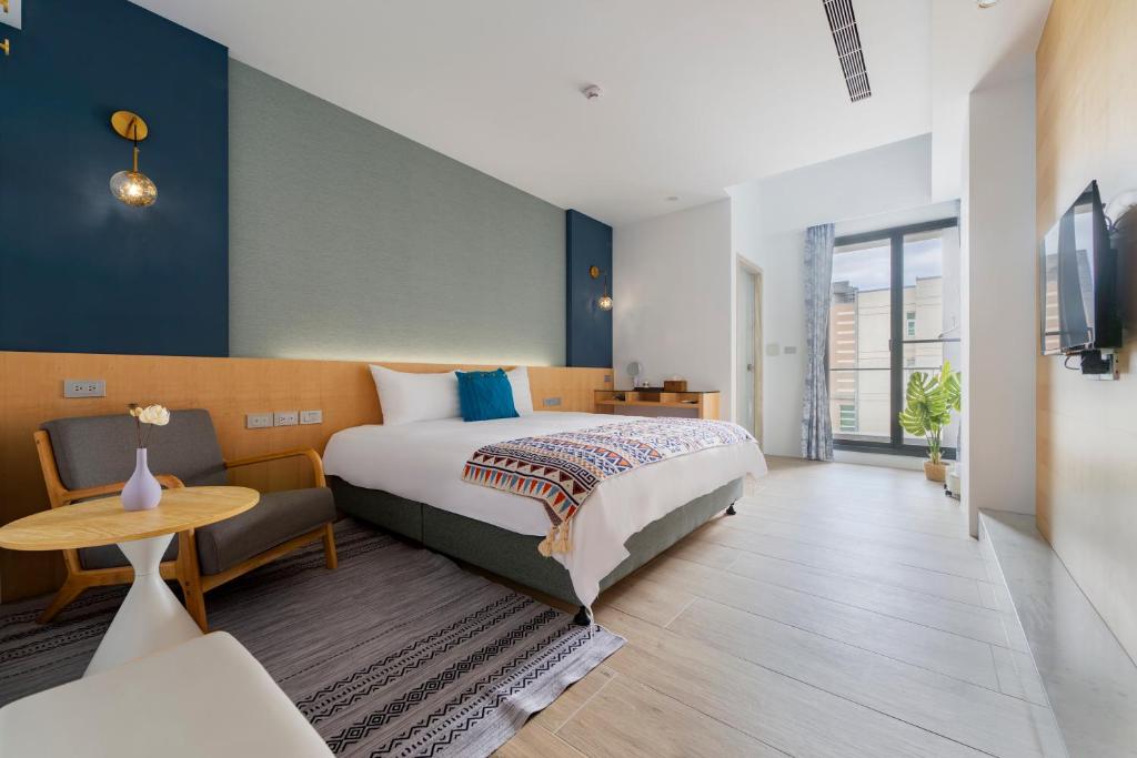 a bedroom with a bed and a table and a desk at Xi Mu in Taitung City