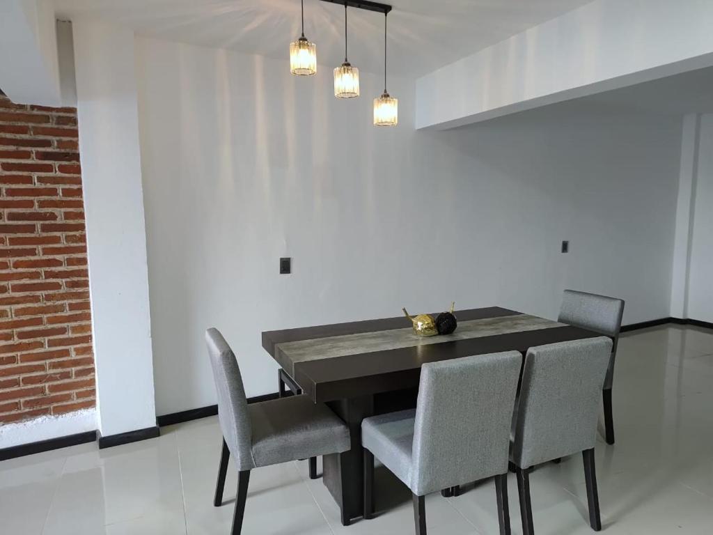 a dining room with a black table and chairs at Hospedaje La Patrona in Chignahuapan