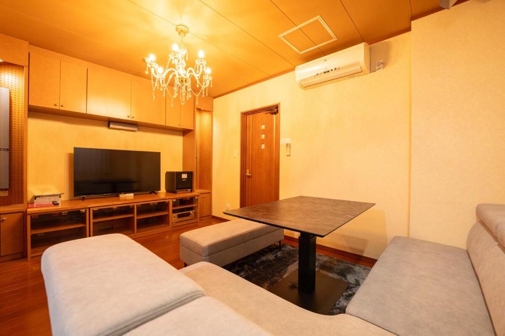 a living room with a couch and a table at HP Jōshin in Nagoya