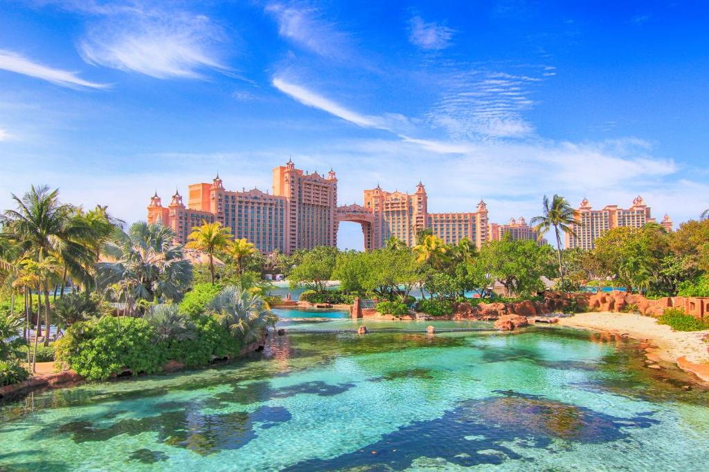 basen w środku ośrodka z palmami i budynkami w obiekcie The Royal at Atlantis w mieście Nassau