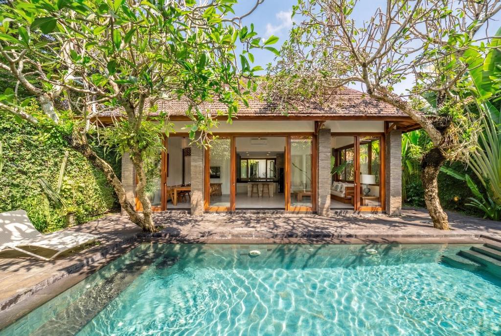 a villa with a pool in front of a house at Mimosa - Private Pool Escape with Panoramic Views in Kerobokan