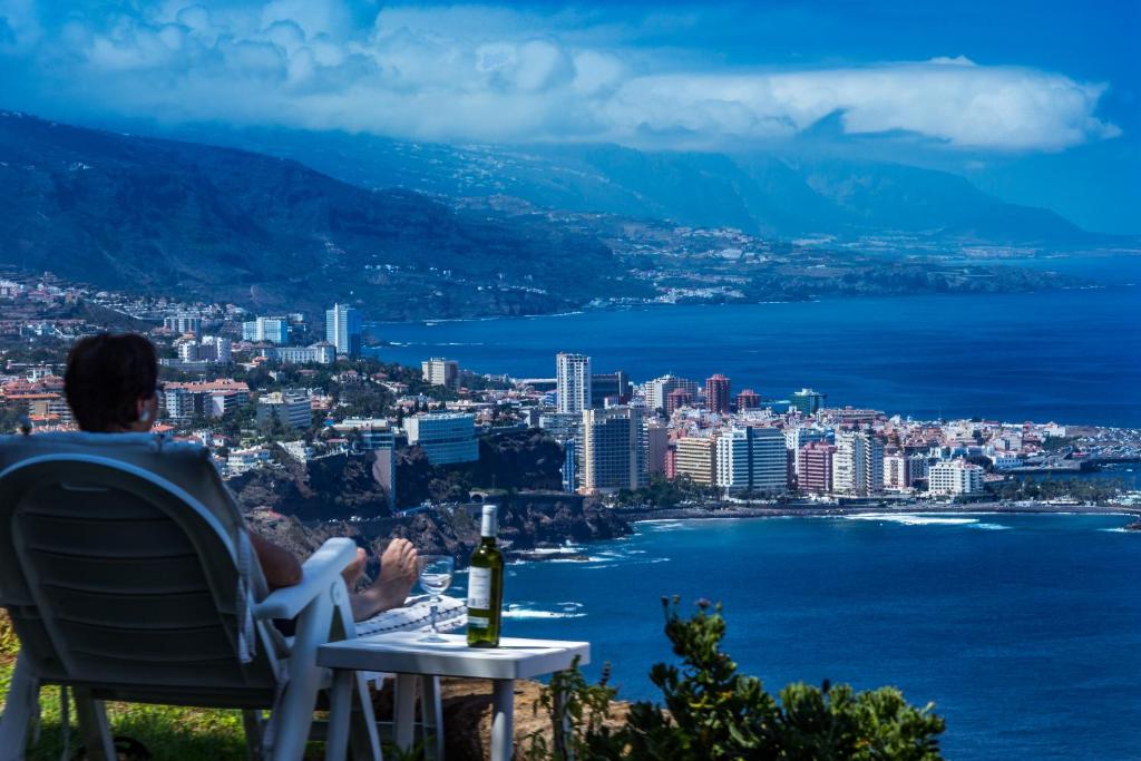 a person sitting at a table with a bottle of wine at Nido Paraiso in Santa Úrsula