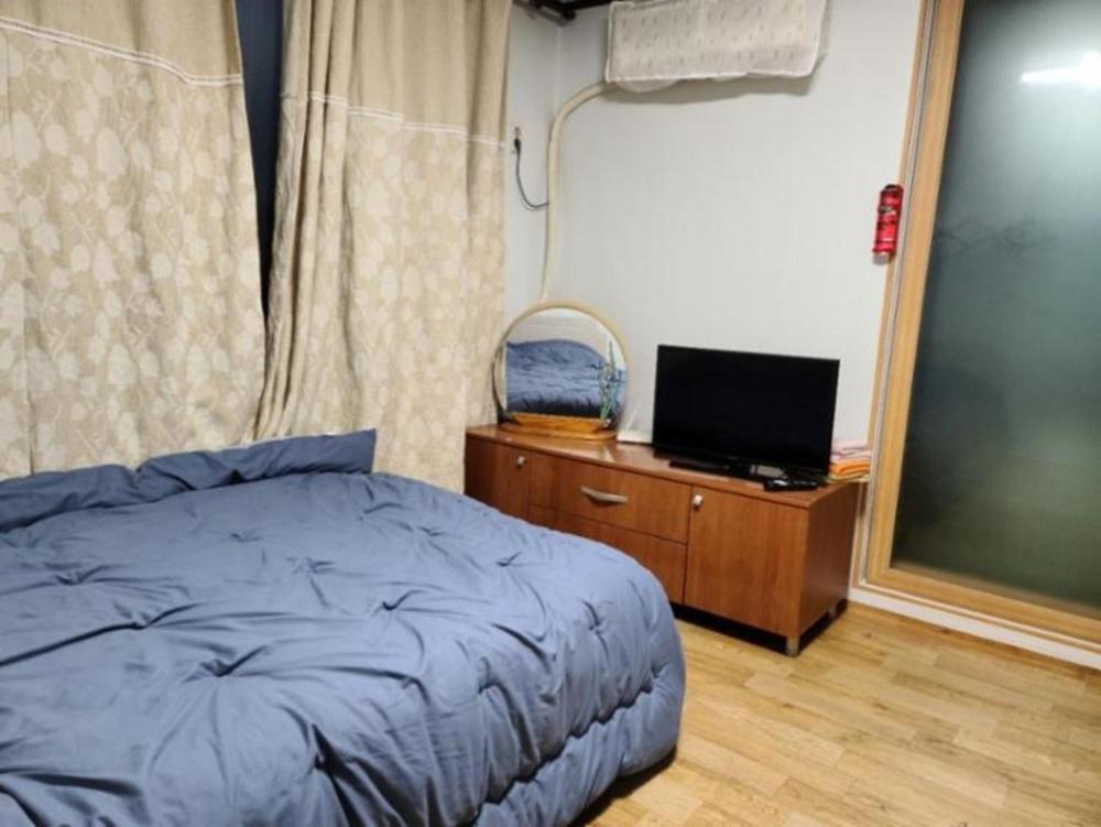 a bedroom with a bed and a tv on a dresser at Chuncheon Saemmul Dungji Pension in Chuncheon