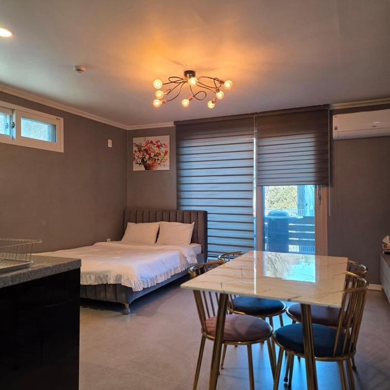 a bedroom with a bed and a table and chairs at Gangneung Moan Pension in Gangneung