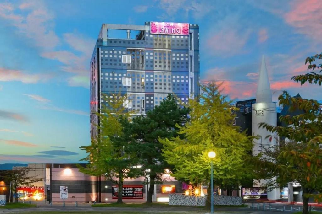 a tall building with a sign on top of it at HOTEL SWING - Couple's Hotel in Beppu