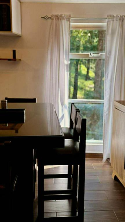 a kitchen with a table and chairs and a window at Villa 2 Senderó del Bosque in Omitlán de Juárez