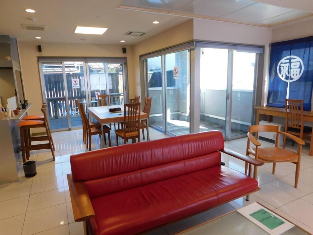 a red couch in a restaurant with a table and chairs at Takayama Fortune-inn in Takayama