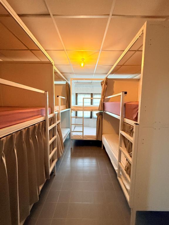 a room with two bunk beds and a hallway at Hostel Cafe13 in Ko Phangan