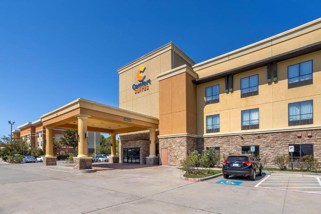 a hotel with a car parked in a parking lot at Comfort Suites Old Town Spring in Spring