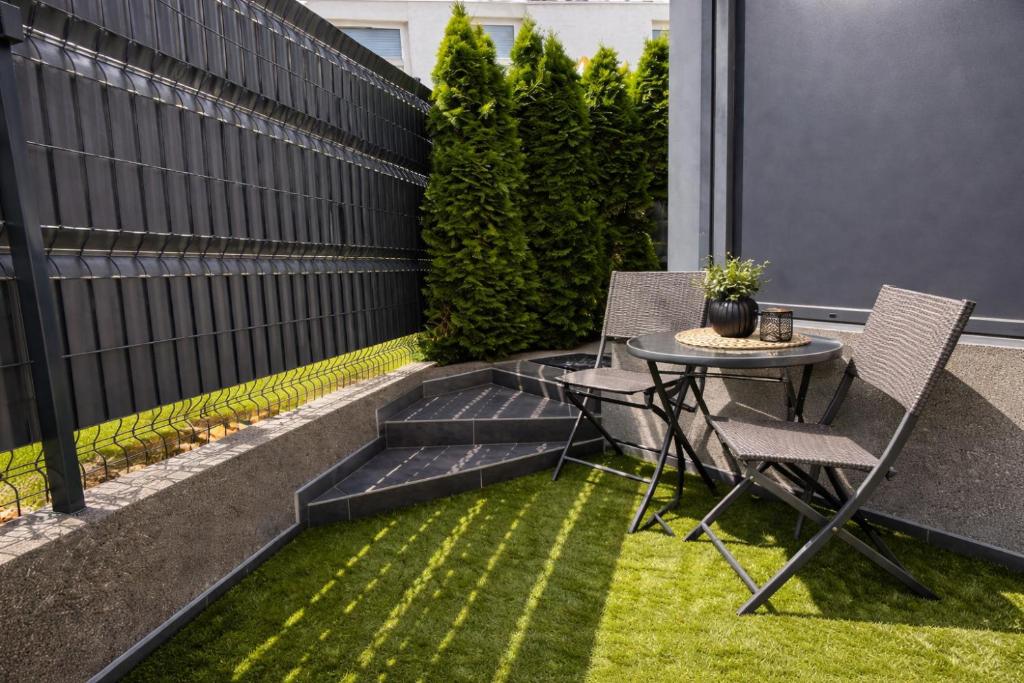 a small patio with a table and chairs on the grass at DINLUX Apartment in Maribor