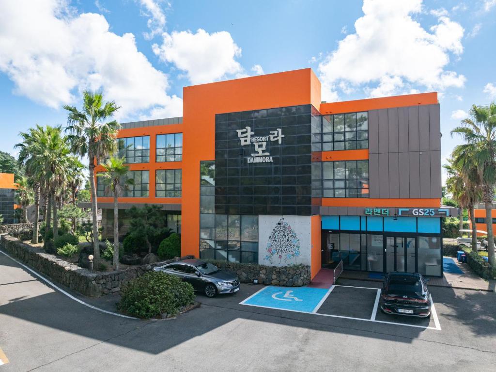 a building with a car parked in front of it at Dammora Resort in Seogwipo
