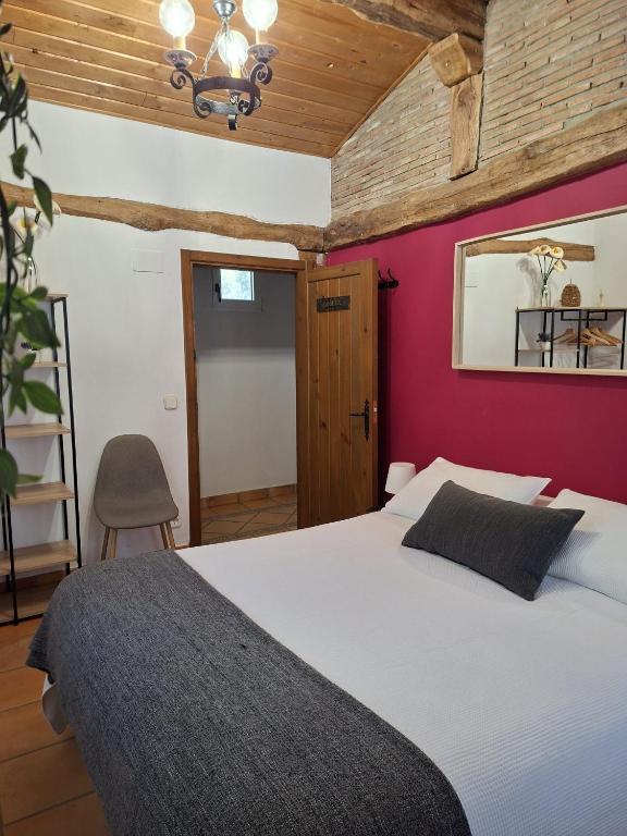 a bedroom with a white bed with a red wall at ANTZOMENDI in Mutriku