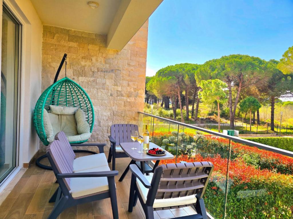 a balcony with chairs and a table and a swing at White Moon Apartment 301 in Lalzit Bay