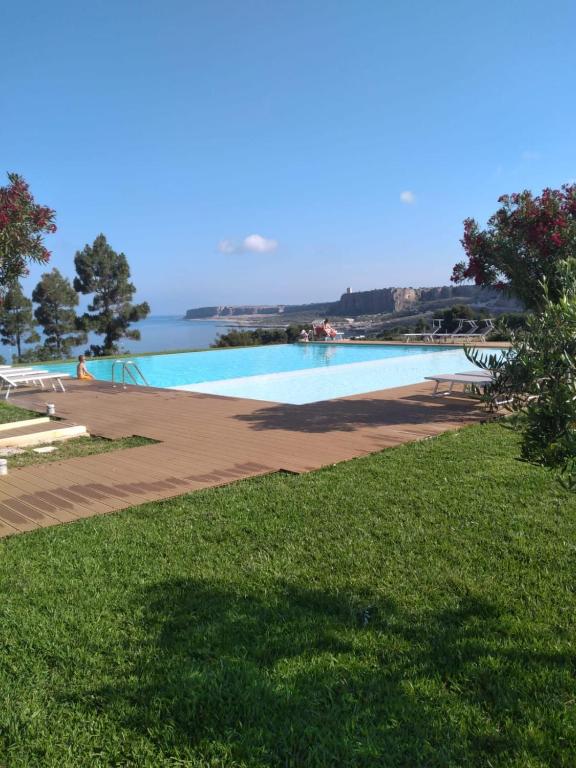 a swimming pool with the ocean in the background at Macari Residence Central Apartment in Macari