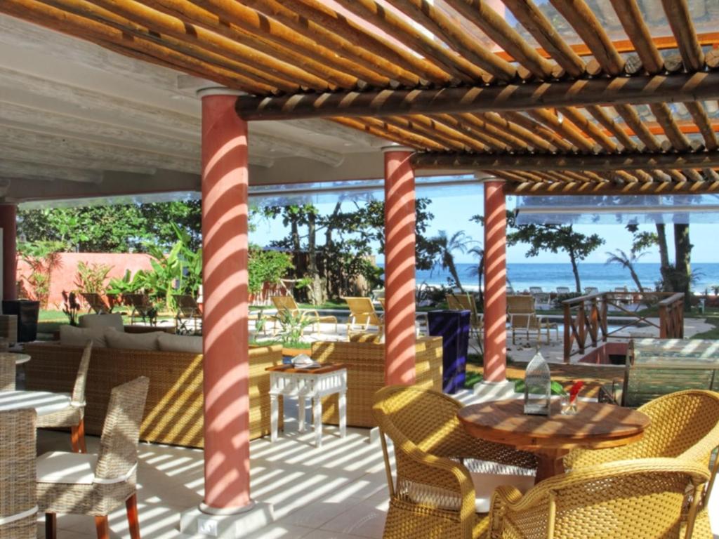a patio with a table and chairs and the ocean at Paradiso Al Mare in Camburi