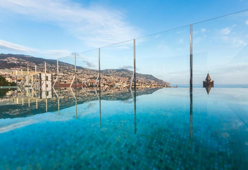 a swimming pool with a view of the water at Castanheiro Boutique Hotel in Funchal