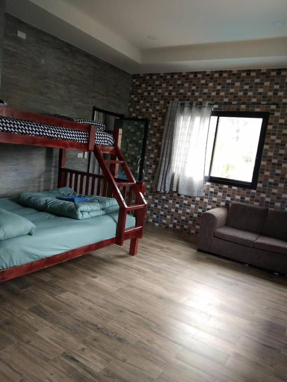 a room with two bunk beds and a couch at Bigland Homestay in Bang Sare