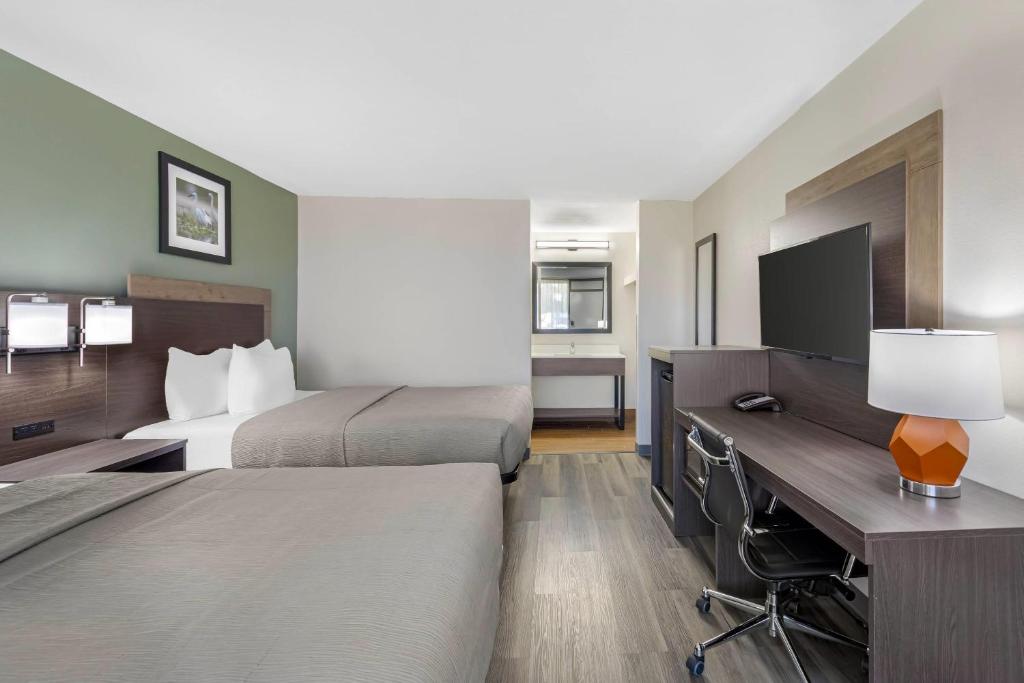 a hotel room with two beds and a desk at Quality Inn Columbus, MS in Columbus